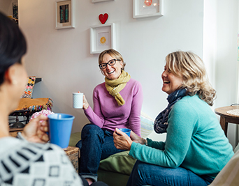 Three friends drinking tea in the living room