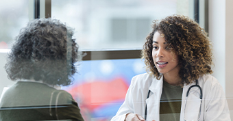 Two people working for medical charities sitting down to discuss how cancer death rate is rising because of the covid-19 lockdown