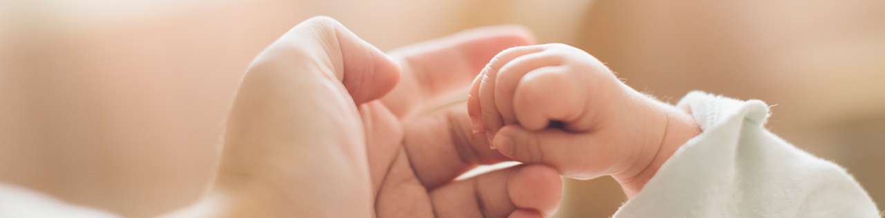 Mother holding her newborn child's hand