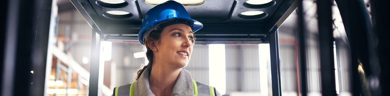 Woman wearing blue helmet in lift of construction site
