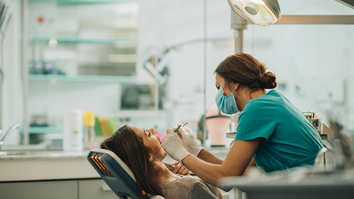 Dentist checking the teeth of a patient at a dental practice