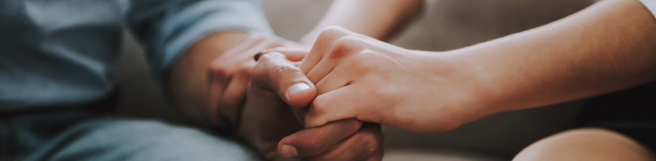 Worried couple holding hands while sitting down
