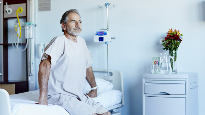 Patient sitting no bed in hospital ward