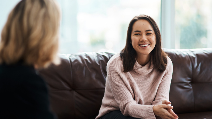 Woman smiling sitting on sofa talking to lawyer about medical negligence claims