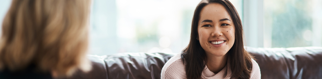 Woman smiling sitting on sofa talking to lawyer about medical negligence claims