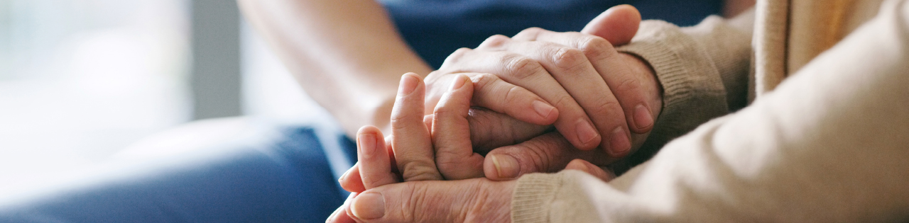 Nurse holding patient's hands who is suffering from sepsis, to help calm the patient