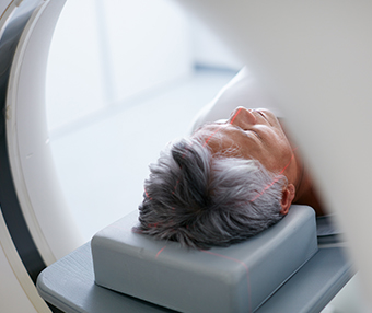 Man lying down getting a CT scan for his brain tumour