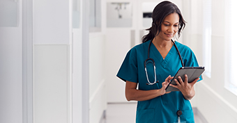 Medical doctor at work in a hospital looking at a tablet screen