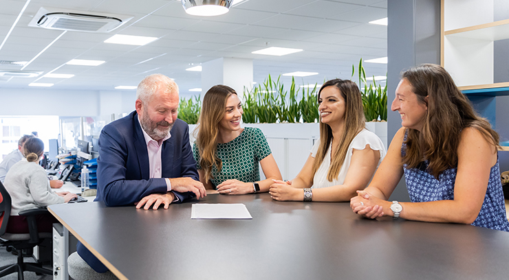 Medical Accident Group team sitting at desk at their office