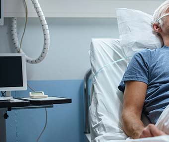 Man lying on hospital bed suffering because of bowel surgery