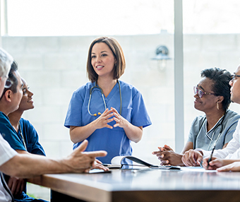 Locum doctor talking to a room full of medical professionals
