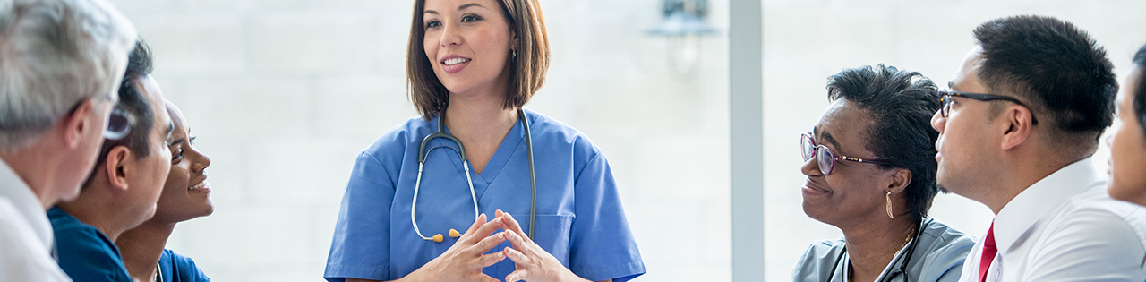 Locum doctor talking to a room full of medical professionals