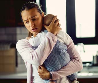 Mother who has gone through trauma and depression due to medical errors holds baby in her arms