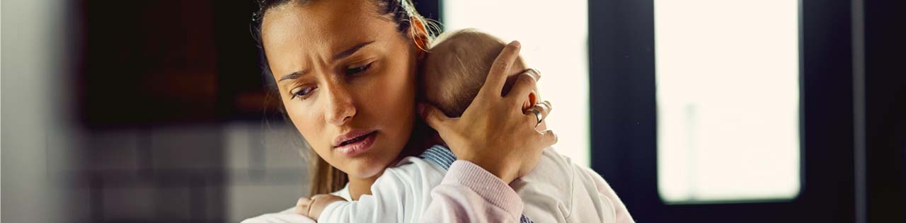 Mother who has gone through trauma and depression due to medical errors holds baby in her arms