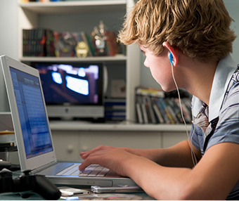 Boy with headphones sitting at his desk suffering from a burst appendix