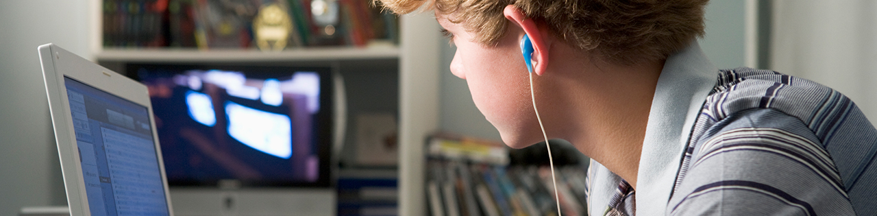 Boy with headphones sitting at his desk suffering from a burst appendix