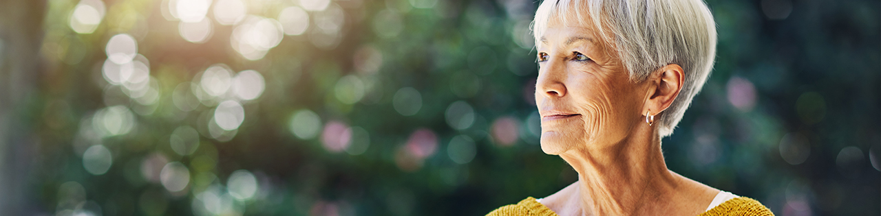 Elderly lady staning outside suffering from Alzheimer's