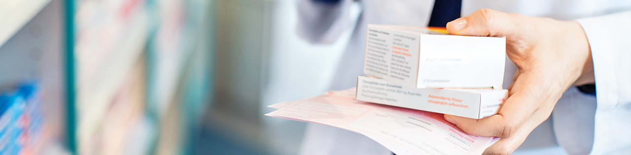 Pharmacist holding medication at a pharmacy